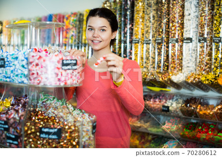 girl buying candies at shop 70280612