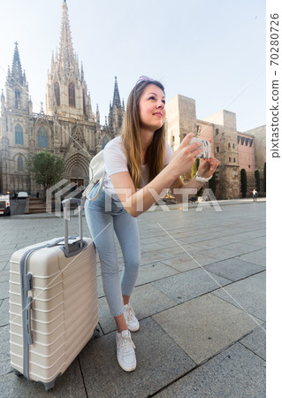 Woman tourist 25-35 years old is taking photo on her phone Woman tourist 25-35 years old is taking photo on her phone 70280726