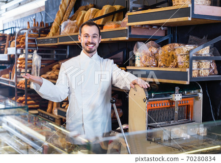 Man seller displaying assortment of bakery Man seller displaying assortment of bakery 70280834