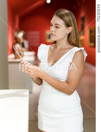 Woman observing museum exposition Woman observing museum exposition 70280839