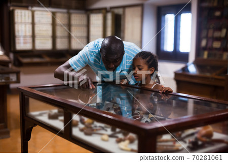 Visitors looking at exhibits in glass stands Visitors looking at exhibits in glass stands 70281061