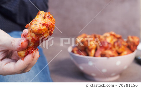 man on the couch with a plate of Buffalo Chicken Wings, copy space man on the couch with a plate of Buffalo Chicken Wings, copy space 70281150