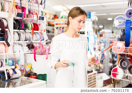 Seamstress looking for ribbons in haberdasher shop Seamstress looking for ribbons in haberdasher shop 70281178