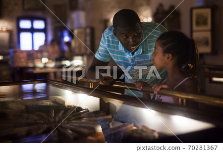 Visitors looking at exhibits in glass stands 70281367