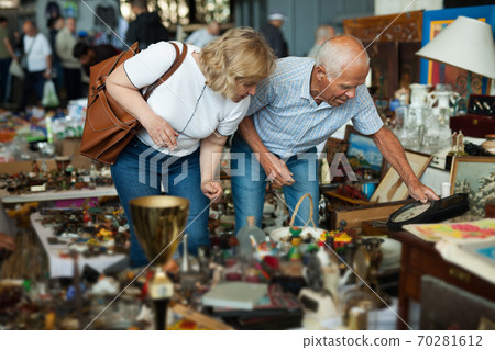 Elderly couple in flea market chooses antique items Elderly couple in flea market chooses antique items 70281612