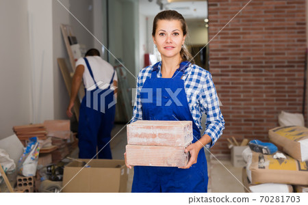 Female worker holding bricks Female worker holding bricks 70281703