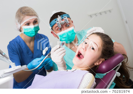 Scared girl in dental chair Scared girl in dental chair 70281974