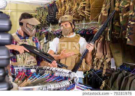 Male customers try on ammunition with weapon Male customers try on ammunition with weapon 70281976