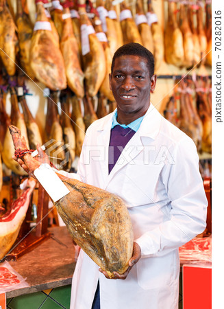 Glad owner of butcher shop selling jamon Glad owner of butcher shop selling jamon 70282016