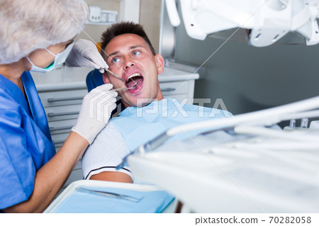 Male patient getting dentist treatment Male patient getting dentist treatment 70282058
