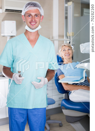 Male dentist standing in dental office Male dentist standing in dental office 70282160