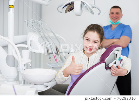 Girl patient in dental office showing ok gesture 70282316
