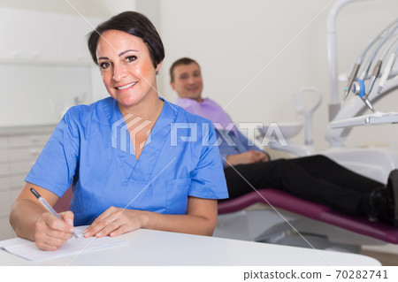 dentist in uniform writing document dentist in uniform writing document 70282741