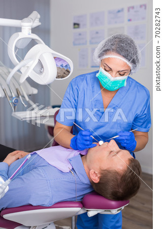 adult dentist checking teeth of patient adult dentist checking teeth of patient 70282743