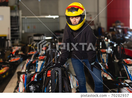 Adult woman in helmet standing near sport cars Adult woman in helmet standing near sport cars 70282937