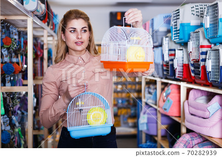Woman choosin cage in pet store Woman choosin cage in pet store 70282939