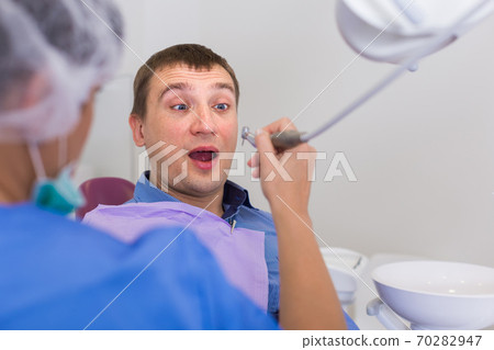 Visitor man afraid of drill sitting Visitor man afraid of drill sitting 70282947