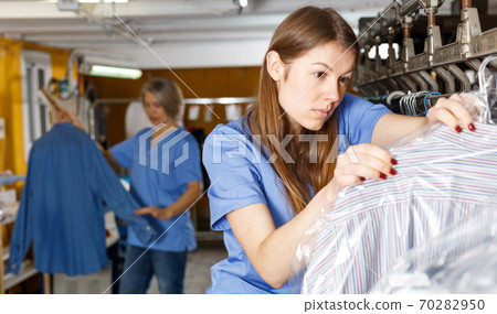 Workers inspecting clothes after cleaning Workers inspecting clothes after cleaning 70282950