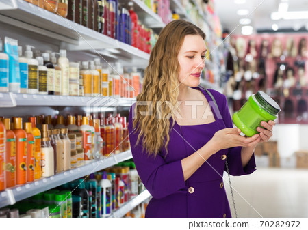 Woman choosing hair care cosmetics in store Woman choosing hair care cosmetics in store 70282972