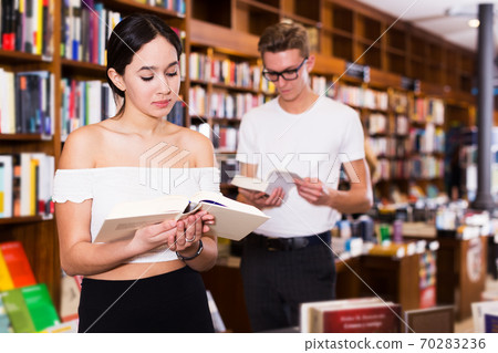 Girl reading books in library 70283236