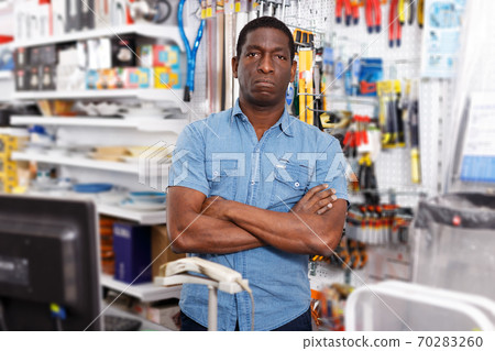 owner of household goods store standing behind counter owner of household goods store standing behind counter 70283260