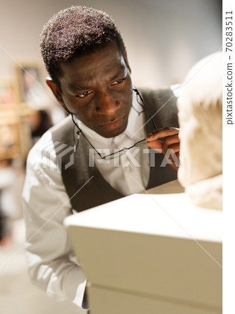 African man looking at exhibit African man looking at exhibit 70283511