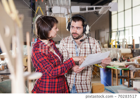 Couple checking drawings while modeling airplanes 70283517