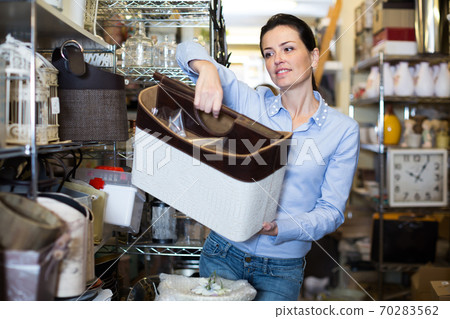 Woman choosing purpose basket at the store 70283562