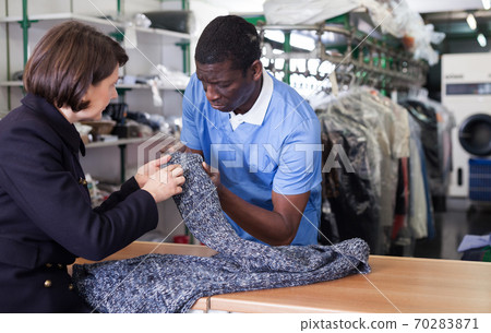 Worker checking clothes of female customer 70283871