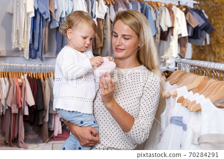 Portrait of woman holding little daughter Portrait of woman holding little daughter 70284291