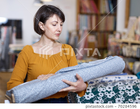 Woman choosing textiles in shop 70284596