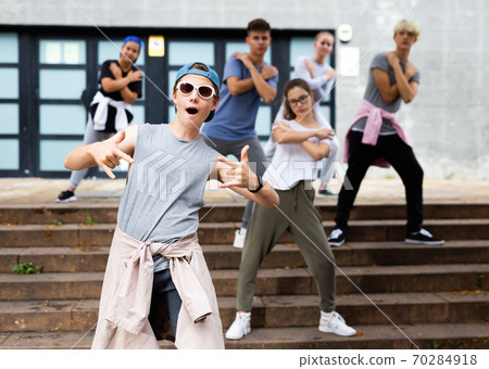 Happy positive teenagers learn dance movements at street Happy positive teenagers learn dance movements at street 70284918