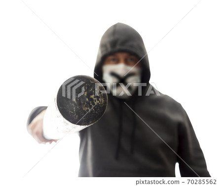 Man in mask and hoodie pokes in face with baseball bat, isolated 70285562