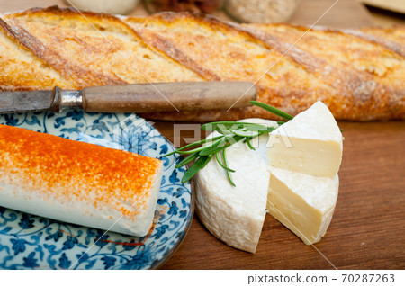 French cheese and fresh baguette on a wood cutter French cheese and fresh baguette on a wood cutter 70287263