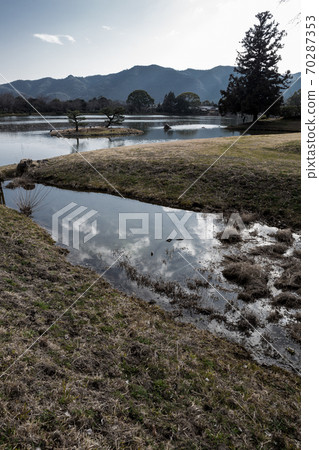 大角寺大門的廢墟,大澤池塘在初春的寒冷天空下靜靜地註滿了水,而冬季的雲層則反映在“平安的供水”中 大角寺大門的廢墟,大澤池塘在初春的寒冷天空下靜靜地註滿了水,而冬季的雲層則反映在“平安的供水”中 70287353