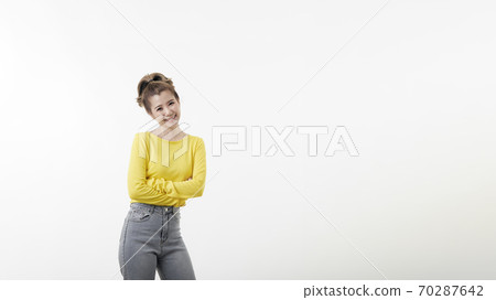 Portrait of smiling young woman with arms crossed 70287642