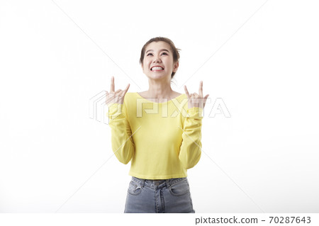 Positive joyful woman makes heavy metal sign Positive joyful woman makes heavy metal sign 70287643