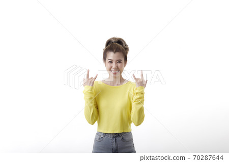 Positive joyful woman makes heavy metal sign Positive joyful woman makes heavy metal sign 70287644