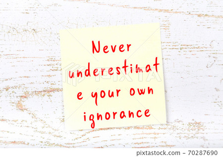 Yellow sticky note on wooden wall with wise quote 70287690