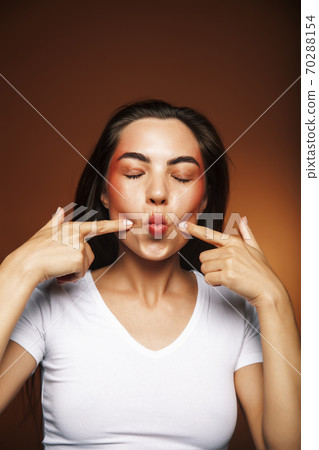 pretty girl happy posing: brunette on brown background, lifestyle people concept pretty girl happy posing: brunette on brown background, lifestyle people concept 70288154