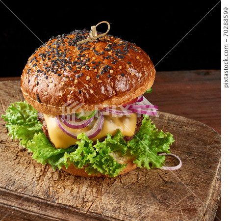 burgers with fried beef cutlet, tomato, lettuce and onions, crispy white wheat flour bun with sesame seeds burgers with fried beef cutlet, tomato, lettuce and onions, crispy white wheat flour bun with sesame seeds 70288599