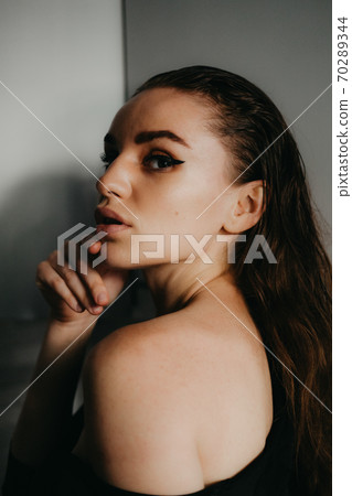 Closeup female portrait. Fashion evening elegance eyeliner makeup on model eyes. Make-up with black eyeliner 70289344