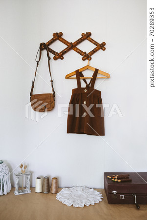 Cute Nursery Decorating Ideas, Baby Room Designs decor. Toddler baby Organic cotton clothes hanging on the rack and rustic retro accessories on white wall. 70289353