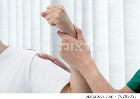 male physiotherapists provide assistance to male patients with elbow injuries to examine patients in rehabilitation centers. Rehabilitation physiotherapy concept 70289355