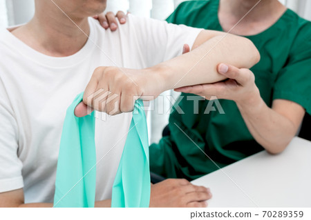 male physiotherapists provide assistance to male patients with elbow injuries to examine patients in rehabilitation centers. Rehabilitation physiotherapy concept male physiotherapists provide assistance to male patients with elbow injuries to examine patients in rehabilitation centers. Rehabilitation physiotherapy concept 70289359