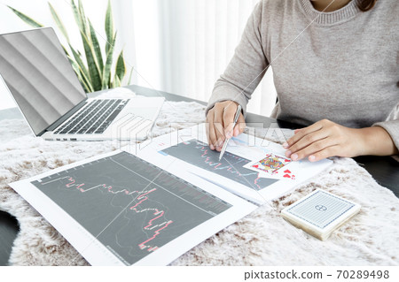The girl's hand is a stockbroker who holds cards and plans a business investment by analyzing and calculating the stock market to find market profits 70289498