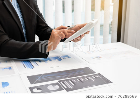 The hands of a male businesswoman use the calculator are analyzing and calculating the annual income and expenses in a financial graph that shows results To summarize balances overall in office The hands of a male businesswoman use the calculator are analyzing and calculating the annual income and expenses in a financial graph that shows results To summarize balances overall in office 70289569