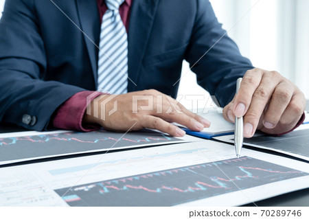 Hand of businessmen are planning business investments related to shares By analyzing and calculating the stock market for marketing profits Hand of businessmen are planning business investments related to shares By analyzing and calculating the stock market for marketing profits 70289746