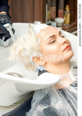 Hairdresser prepare to washes off the dye Hairdresser prepare to washes off the dye 70290388