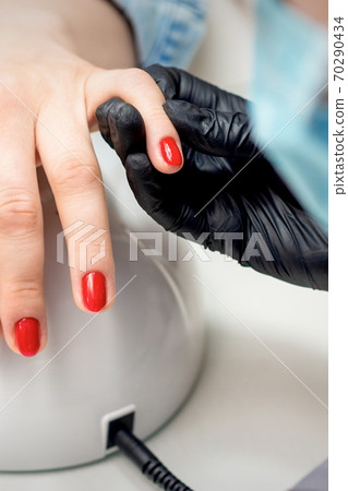 Young woman receives red nail polish 70290434